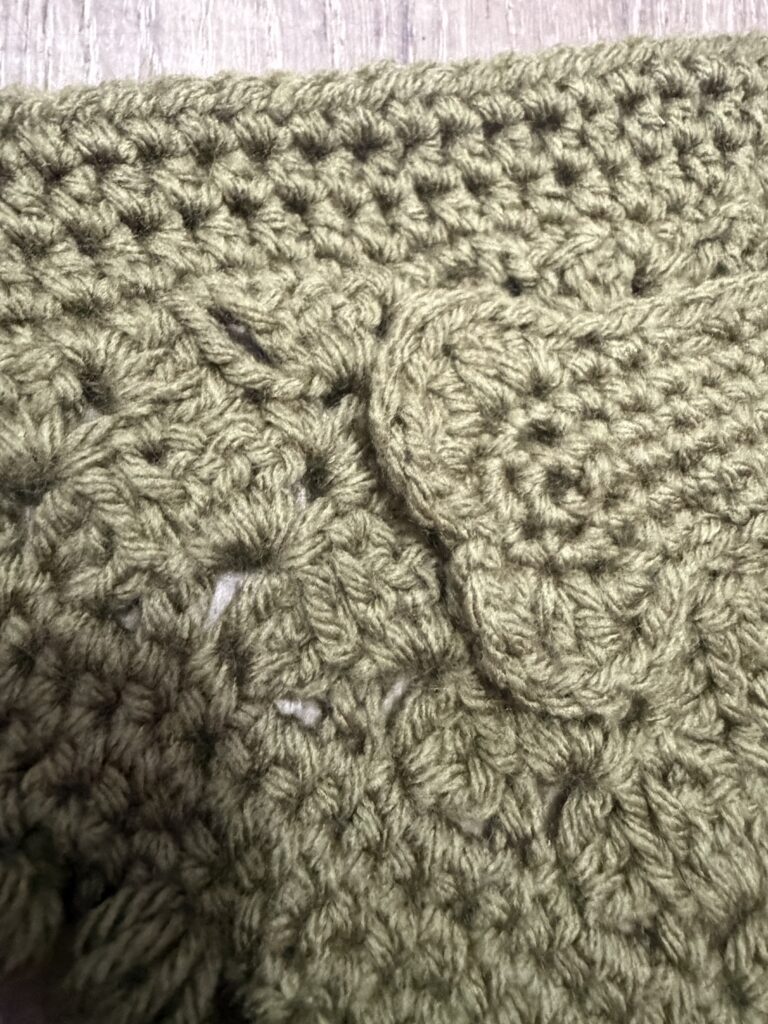 Close-up of handmade crochet pet bandana stitch work and appliqué detail