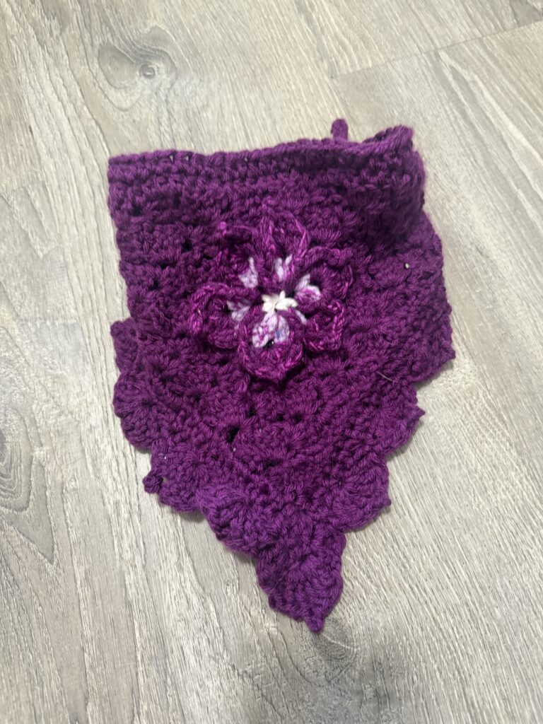 Handmade crochet pet bandana customized with a flower appliqué